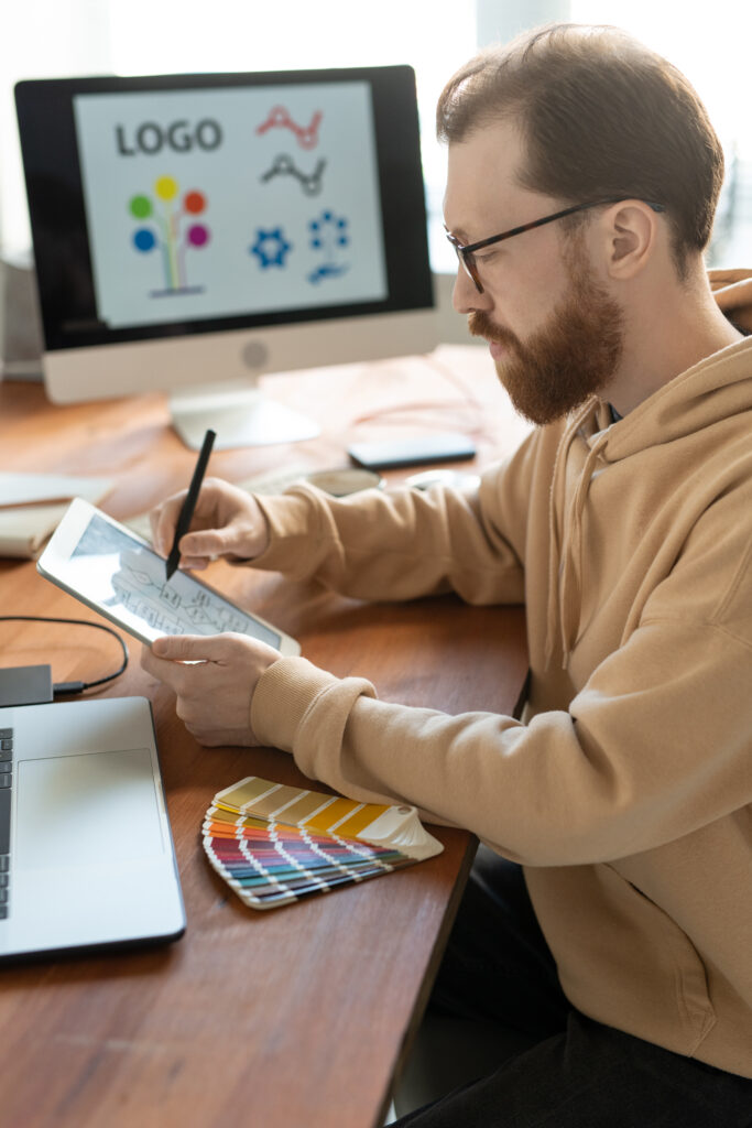 Guy building a brand working on a logo and concept through an tablet.